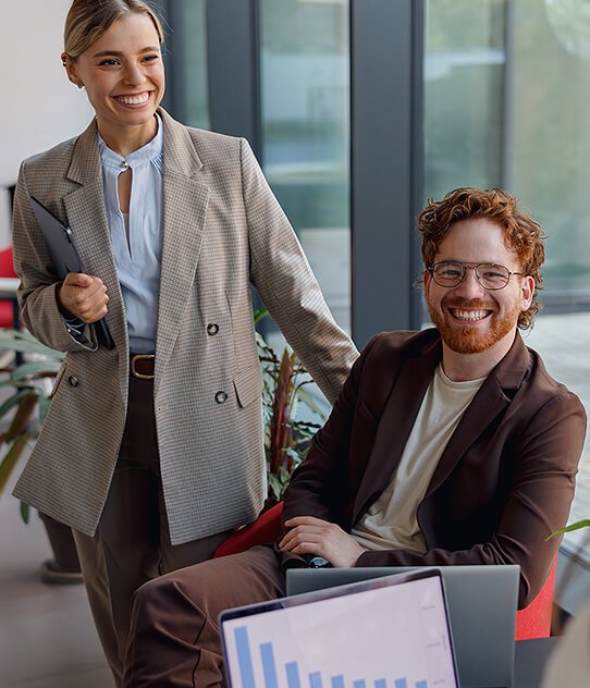A man is sitting besides a standing woman the best Marketing Agency in Hyderabad
